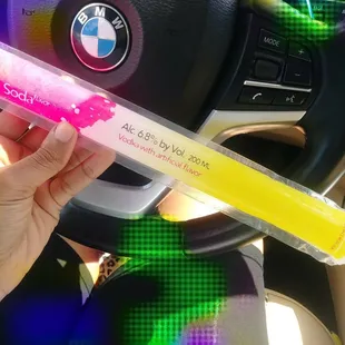 a hand holding a tube of liquor