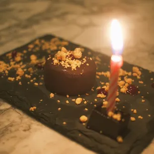 a chocolate cake with a lit candle