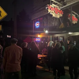 a crowd of people standing outside at night
