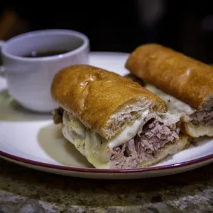 French Dip made of thinly sliced prime rib roast on a house made roll with aged provolone. Side of au jus and fries