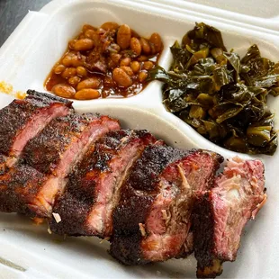 a plate of meat, beans, and greens