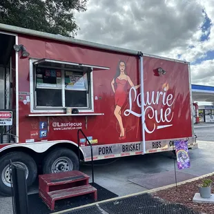 a red food truck parked in a parking lot