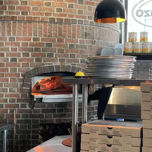 a woman putting pizza into the oven
