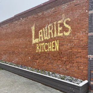a painted sign on a brick wall