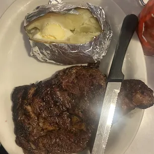 a steak and a potato on a plate