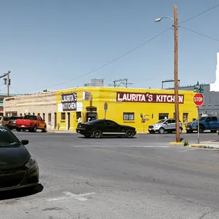 a black car parked in front of a yellow building