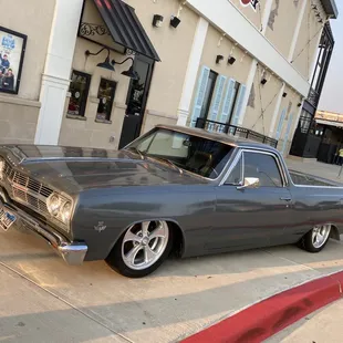 a classic car parked in front of a building