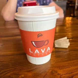 a woman sitting at a table with a cup of coffee