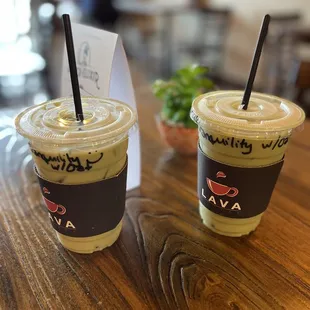 two cups of iced coffee on a wooden table