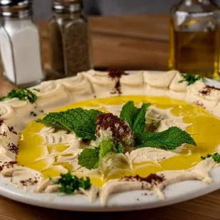a plate of hummus and olive oil