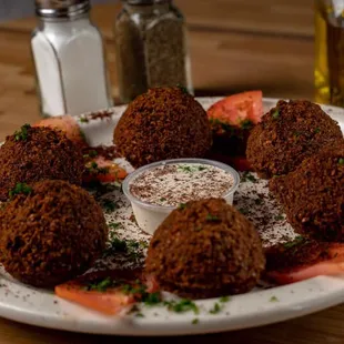 a plate of fried meatballs and tomatoes