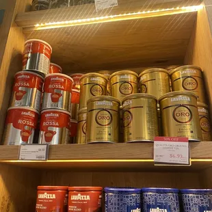 a shelf of coffee and tea cans