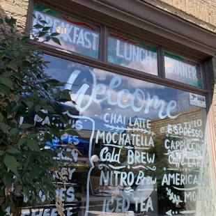 a window of a restaurant with a menu written on it