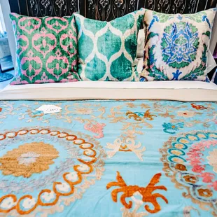 Ikat pillow covers and hand-embroidered bed scarf.