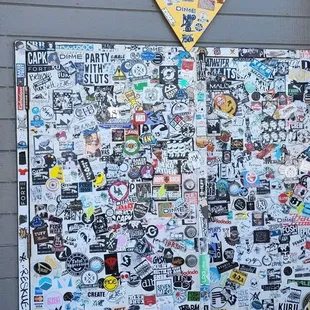 a pizza sign covered in stickers