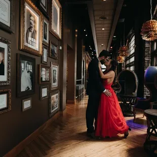 a man and woman in a red dress standing in a hallway