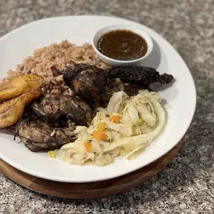 Jerk Chicken seasoned with a blend of our family's Jamaican spices and herbs, grilled to perfection. includes rice n peas + two sides.