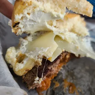 a hand holding a half eaten sandwich