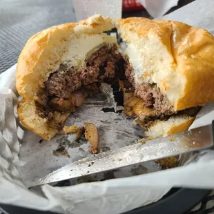 a half eaten sandwich with a knife