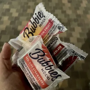 a hand holding a bag of gummies