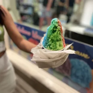 a person holding a cone of ice cream