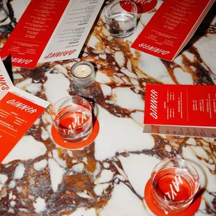 a marble table with red menus on it