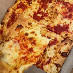 a hand holding a slice of pizza