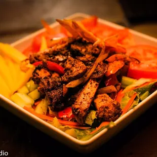 a bowl of salad with meat and vegetables