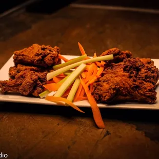 a plate of fried chicken with carrots and celery