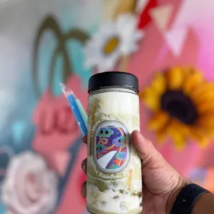 a hand holding a jar of milk