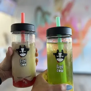 a hand holding two drinks