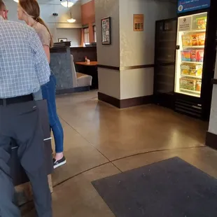 a man and a woman standing in front of a refrigerator