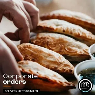 a person grabbing a piece of empanadas