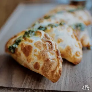 two empanadas on a cutting board