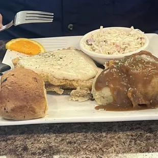 Country fried chicken with brown gravy over mashed potatoes and cranberry coleslaw and cranberry roll