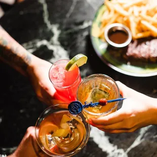 two people clinking glasses of drinks