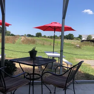 a table and chairs with red umbrellas