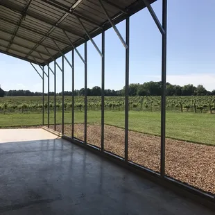 a covered patio with a view of a vineyard