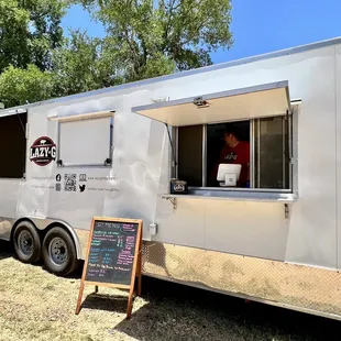 a woman looking out of the window of a food truck