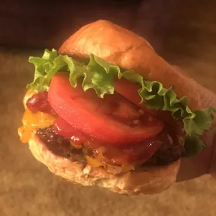 a hand holding a hamburger