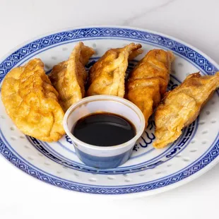 a blue and white plate of fried food