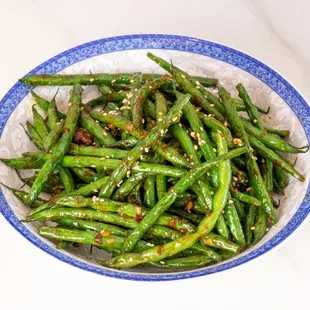 a bowl of green beans with sesame seeds