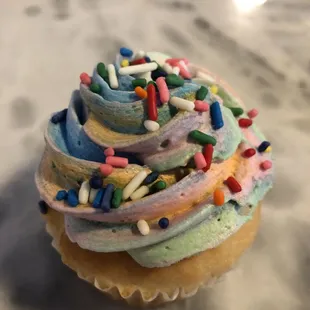 a frosted cupcake with sprinkles