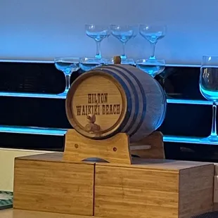 a wooden barrel with wine glasses on top