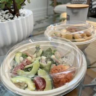 two plastic bowls of food on a glass table