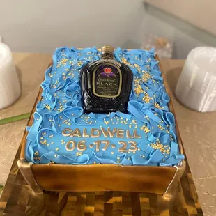 a cake with a bottle of cologne on it