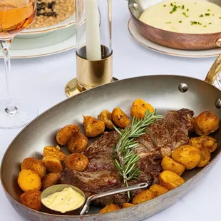 a steak and potatoes in a pan