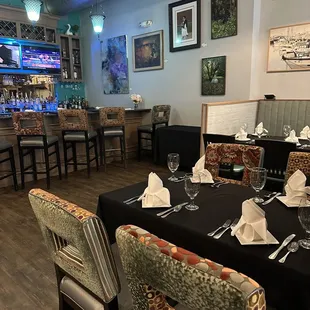 a dining room with a bar in the background