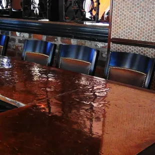 a bar with a long table and blue chairs