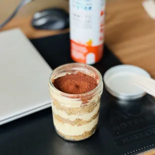 a jar of coffee next to a laptop